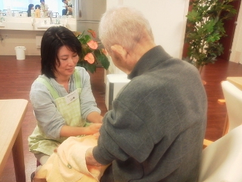 有料老人ホームでのハンドケア。施術する山本さんのやさしさが表情ににじむ